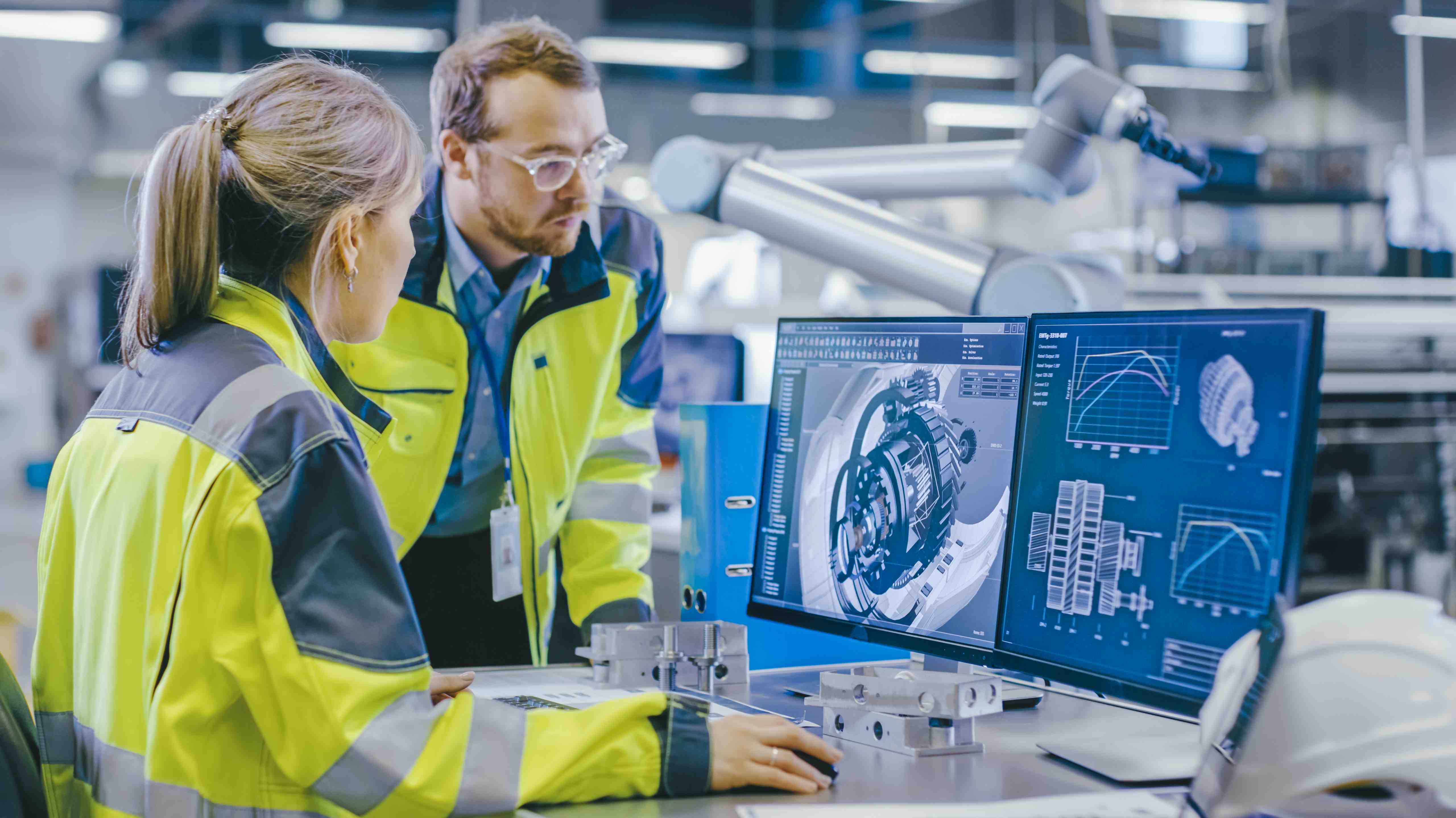 At the Factory: Male Mechanical Engineer Holds Component while F